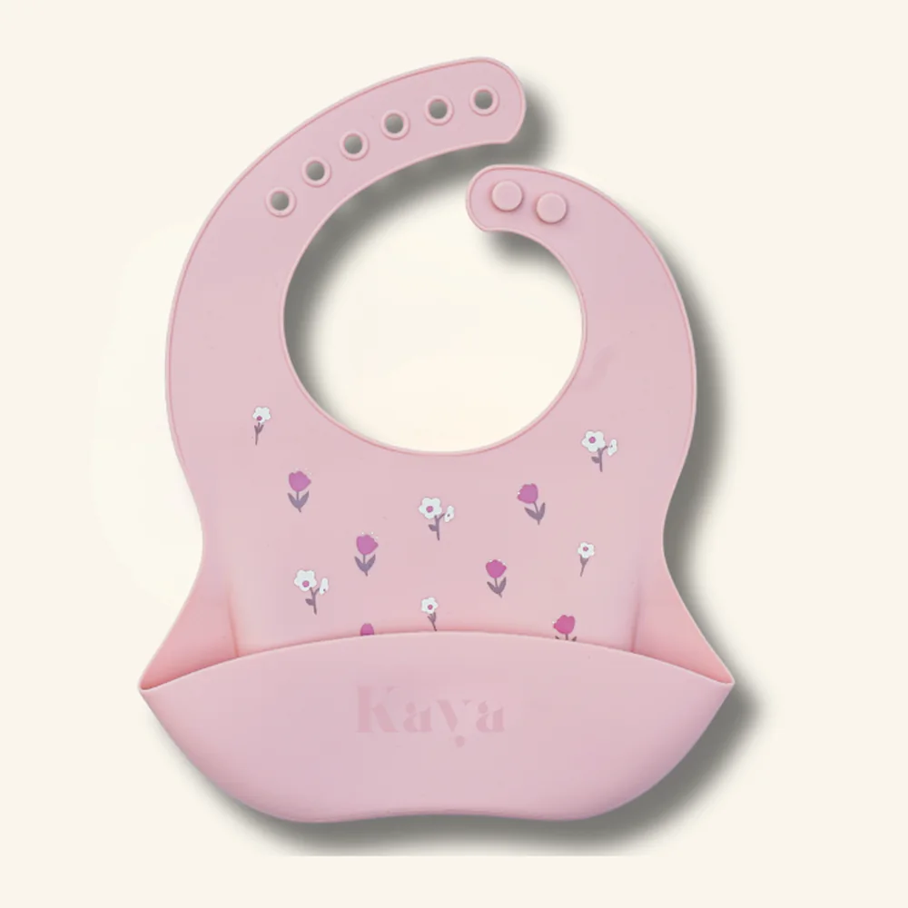 KAYA 2-pack of silicone baby bibs in pink and ivory white, both with a small wildflower print and a deep food-catcher pocket