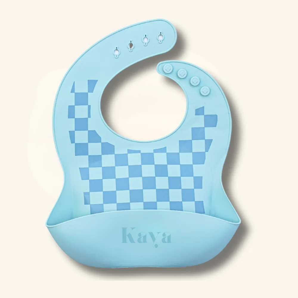 KAYA 2-pack of silicone baby bibs: a slate blue bib and a light blue checkered bib, each with a food-catcher pocket and adjustable snap neck